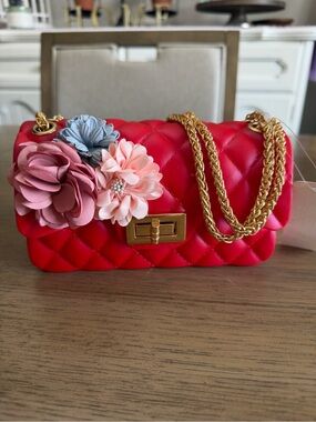 Red jelly bag, gold hardware, and floral accents